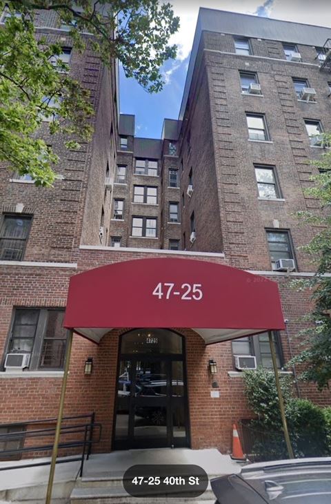 an apartment building with a red awning over the front door