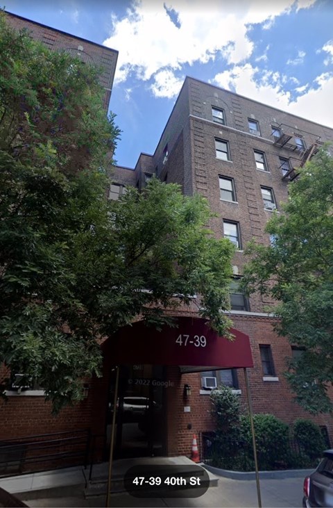 the apartment building has a red awning in front of it