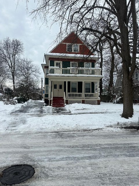 a white house with a red roof in the snow