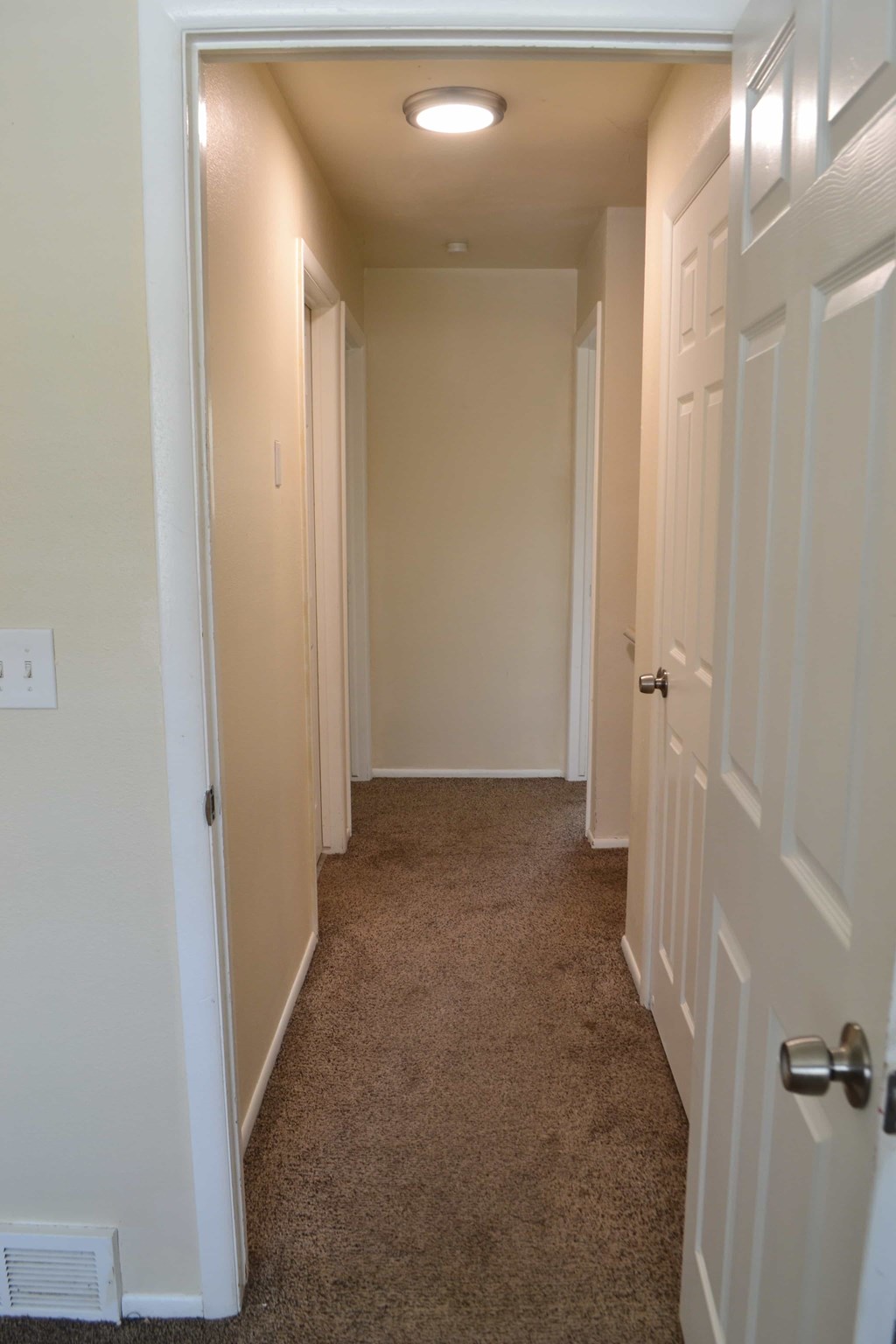 a hallway with a carpeted floor and white doors
