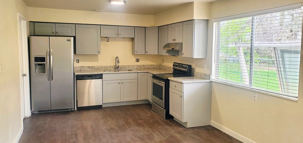 a kitchen with white cabinets and stainless steel appliances