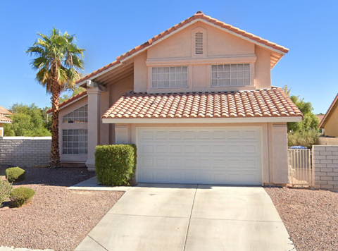 a house with a white garage door and a palm tree