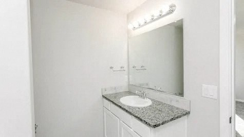 a white bathroom with a sink and a mirror