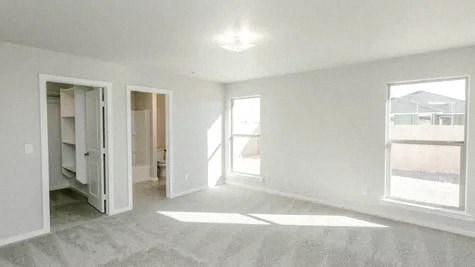 an empty living room with two doors and a window