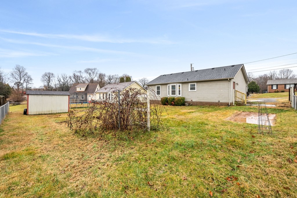 a row of houses in a grassy yard with a fence