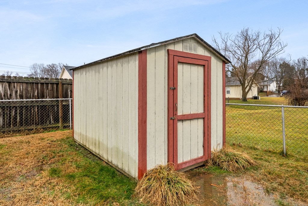 the side of a small building with a red door