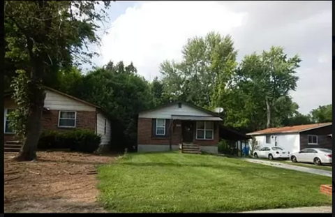 a house with a yard and cars parked in front of it