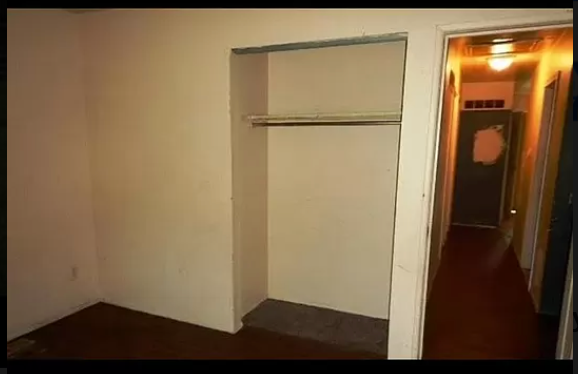 an empty room with a white wall and a door