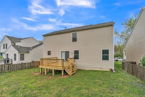 a backyard with a wooden deck and a house