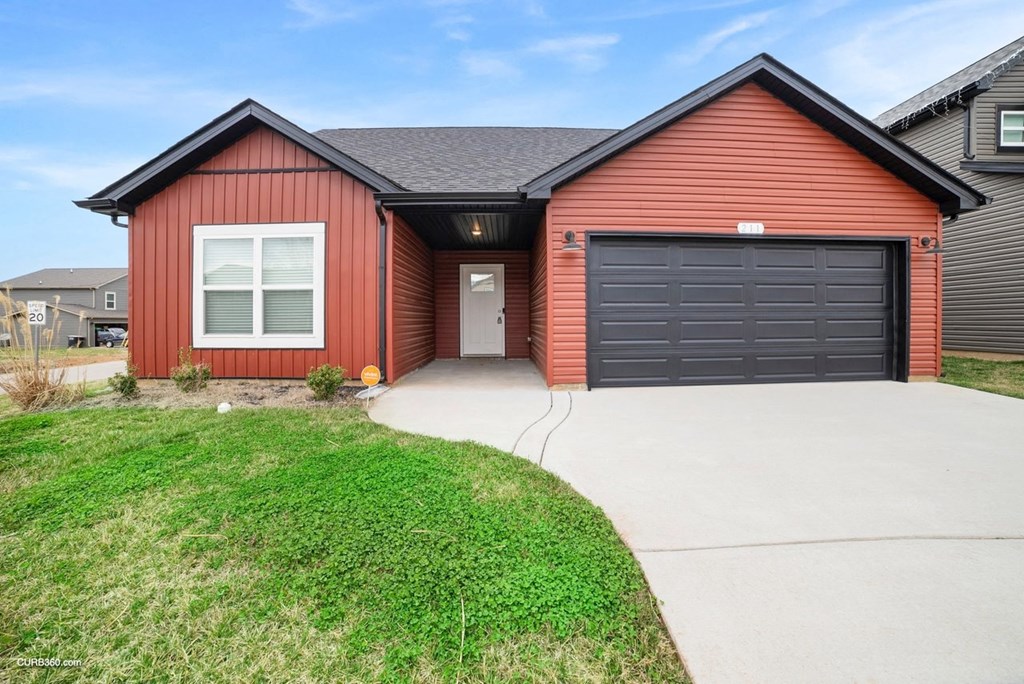 a red house with a driveway and a garage door
