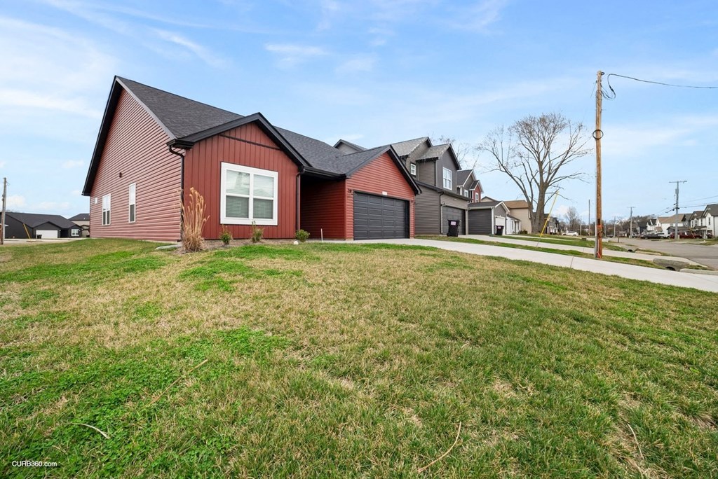 a red house with a yard in front of it