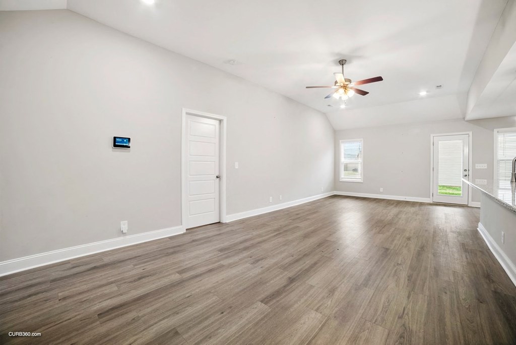 an empty living room with white walls and a ceiling fan