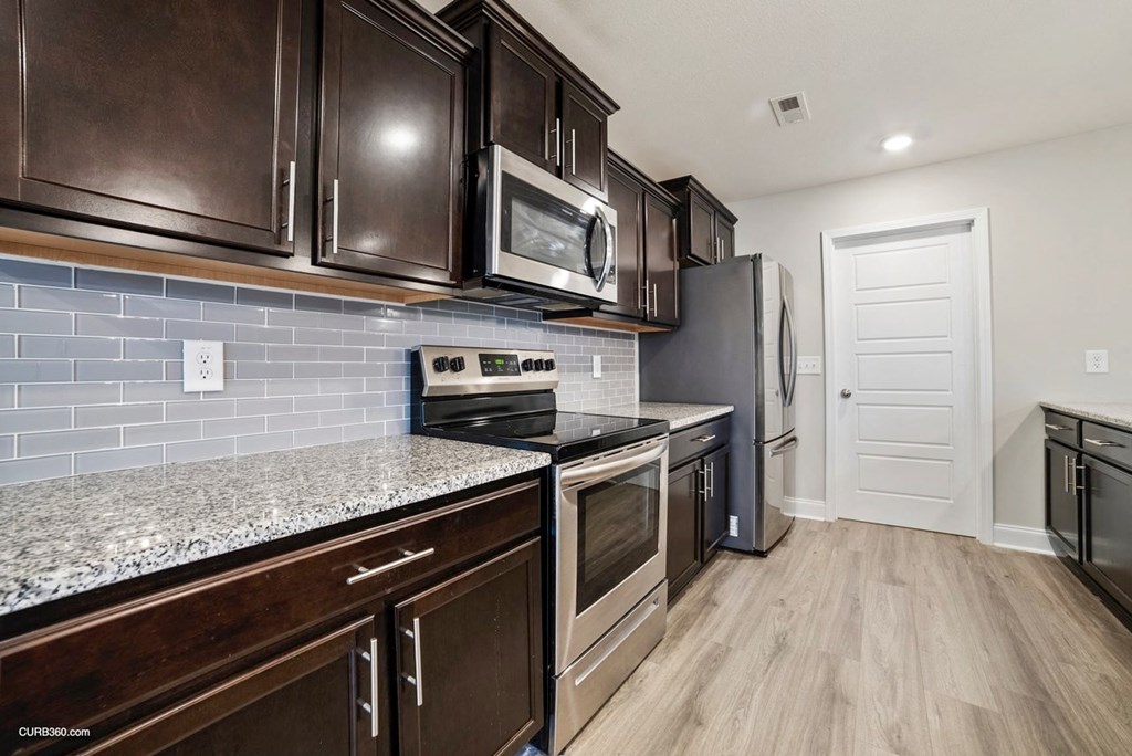 a kitchen with stainless steel appliances and marble counter tops