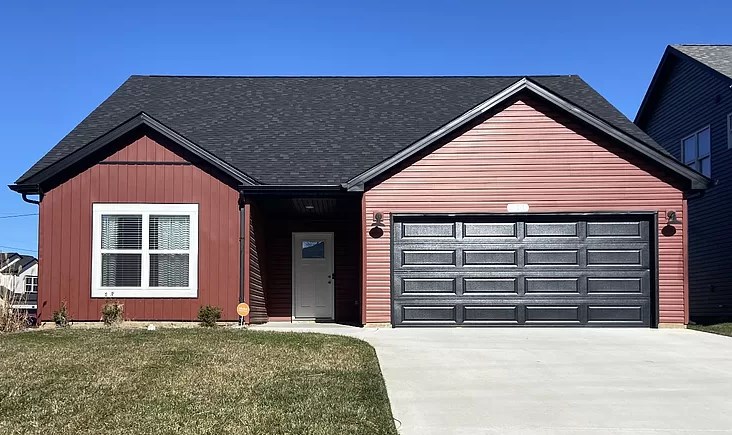 a red house with a black garage door