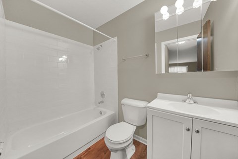 A white bathroom with a toilet, sink, and bathtub.