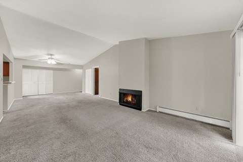 A spacious living room with a fireplace in the middle.
