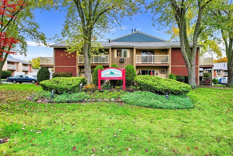 A red sign with white lettering is in front of a building.