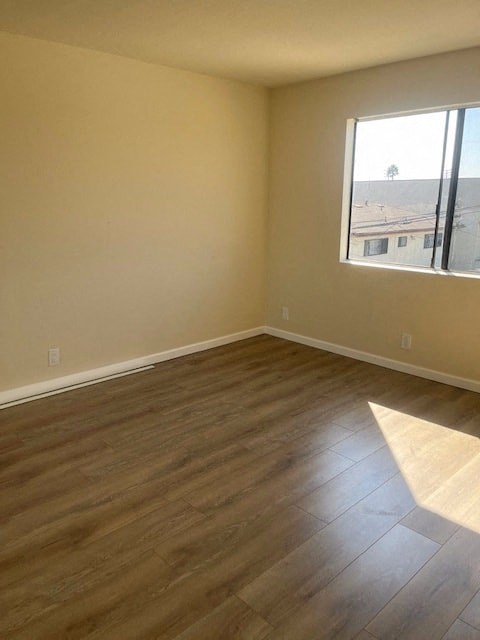 an empty living room with wooden floors and a window