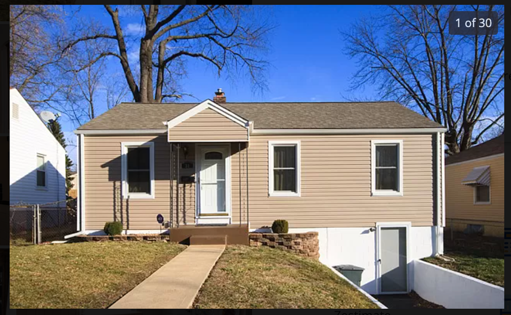A house with a brown roof and a white fence.