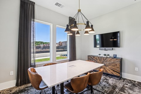 A modern dining room with a large table and chairs.
