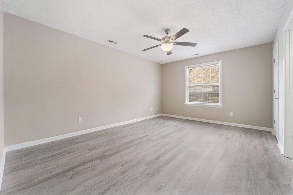 A room with a ceiling fan and a window.