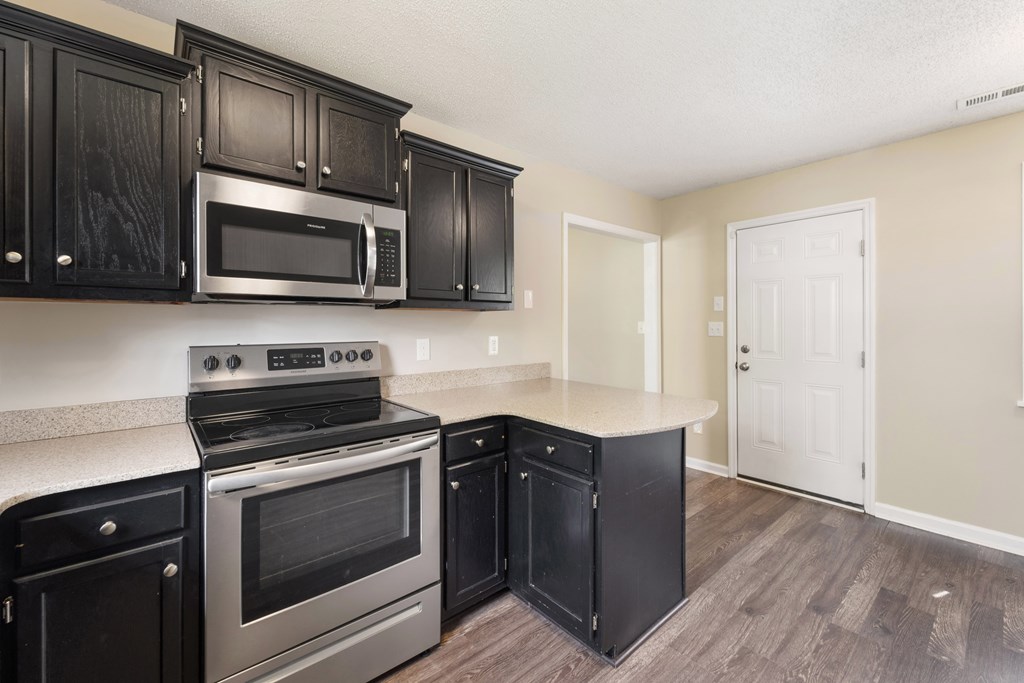 A kitchen with black cabinets and stainless steel appliances.