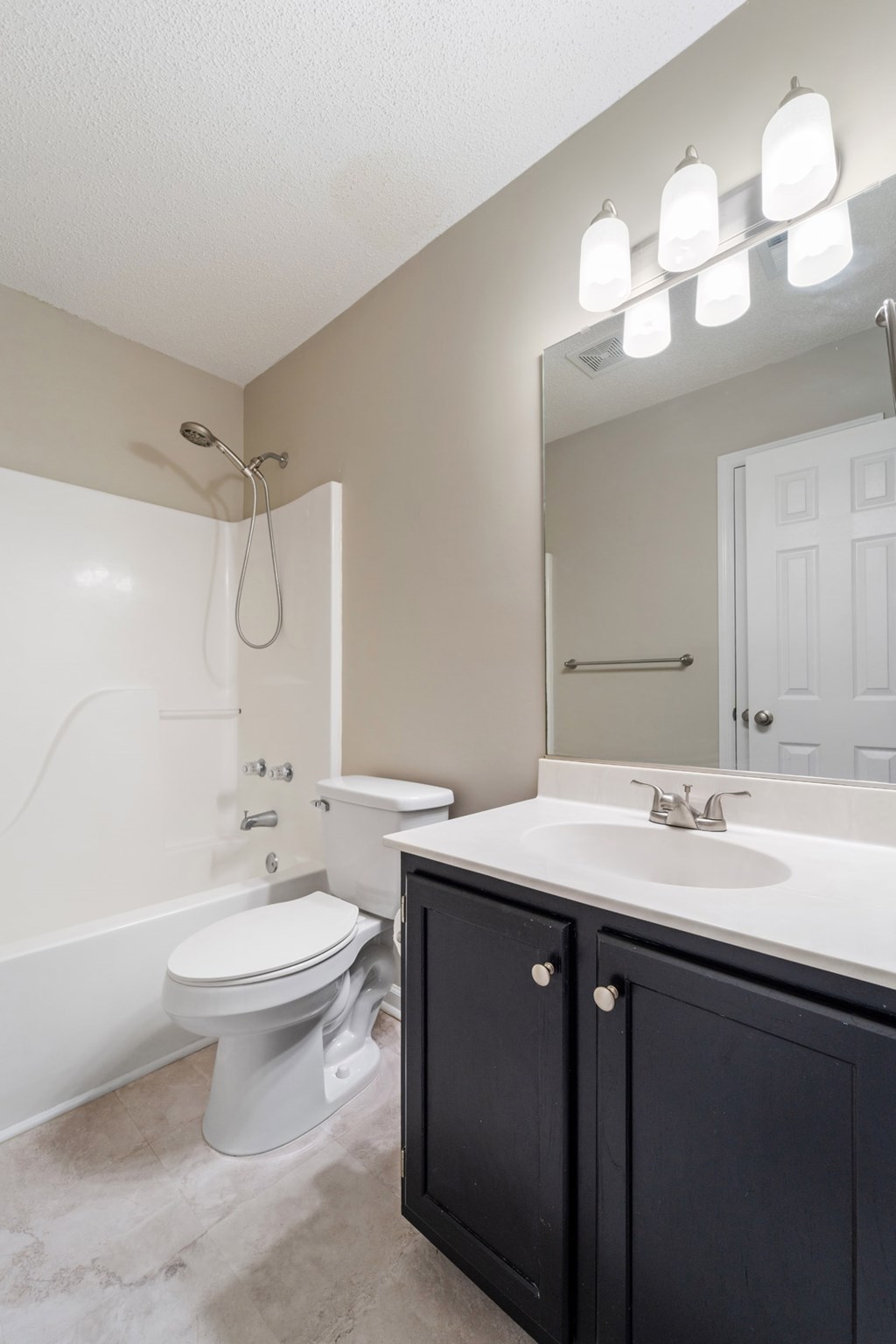A white toilet sits in a bathroom next to a sink.
