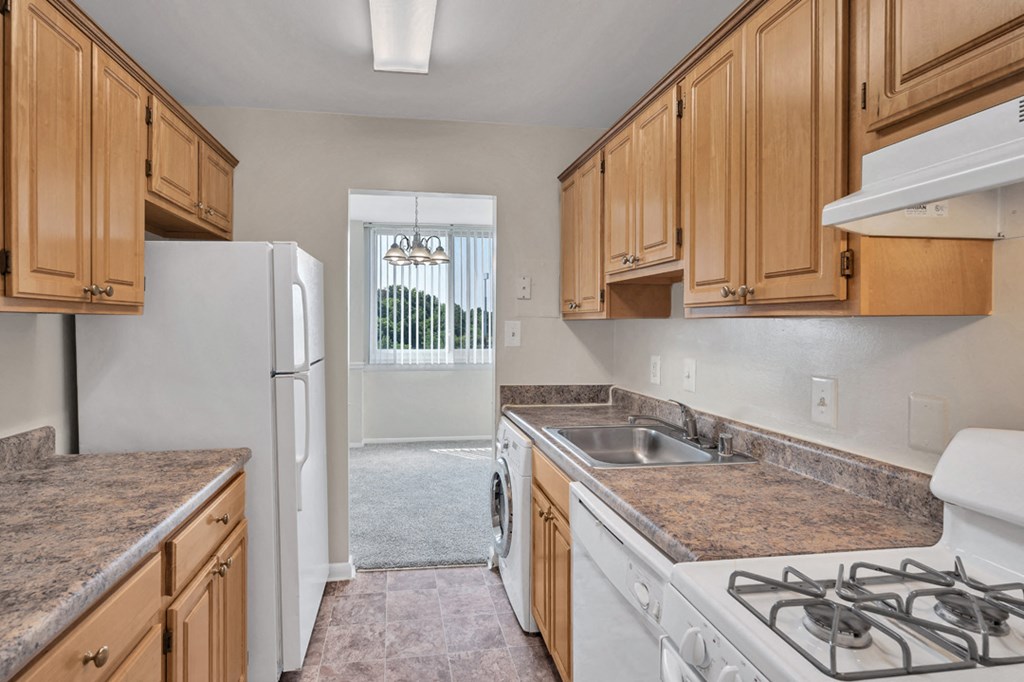 a kitchen with white appliances and wooden cabinets