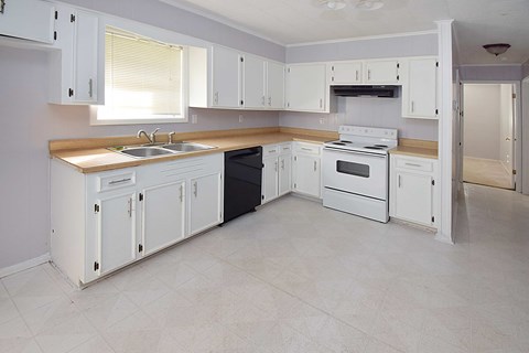 A kitchen with white cabinets and appliances.