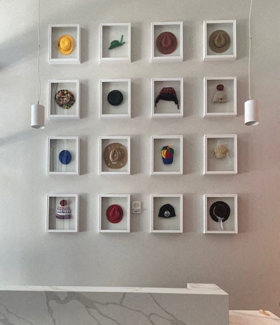 a wall with a bunch of hats hanging on it