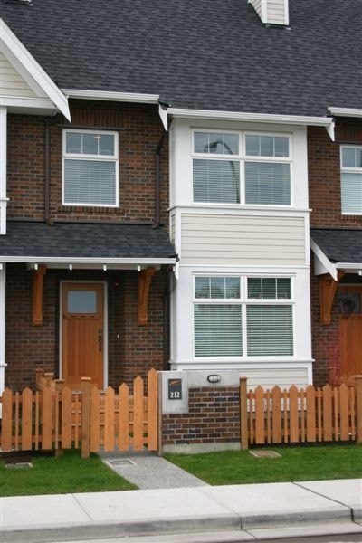 A house with a brown door and a white fence.