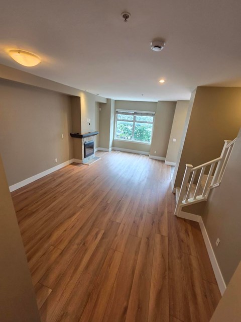 A room with wooden floors and a staircase.