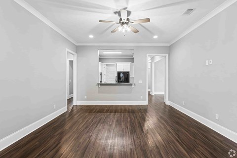 A room with wooden floors and a ceiling fan.