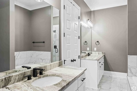 A bathroom with a marble countertop and a white door.