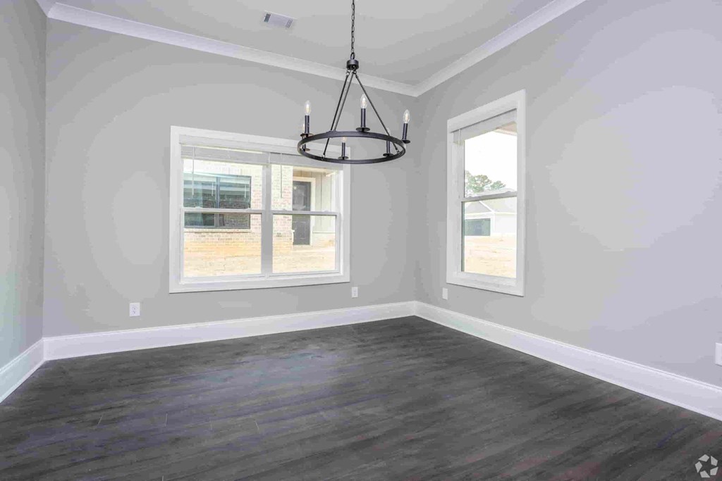 A room with a grey wall and a wooden floor.