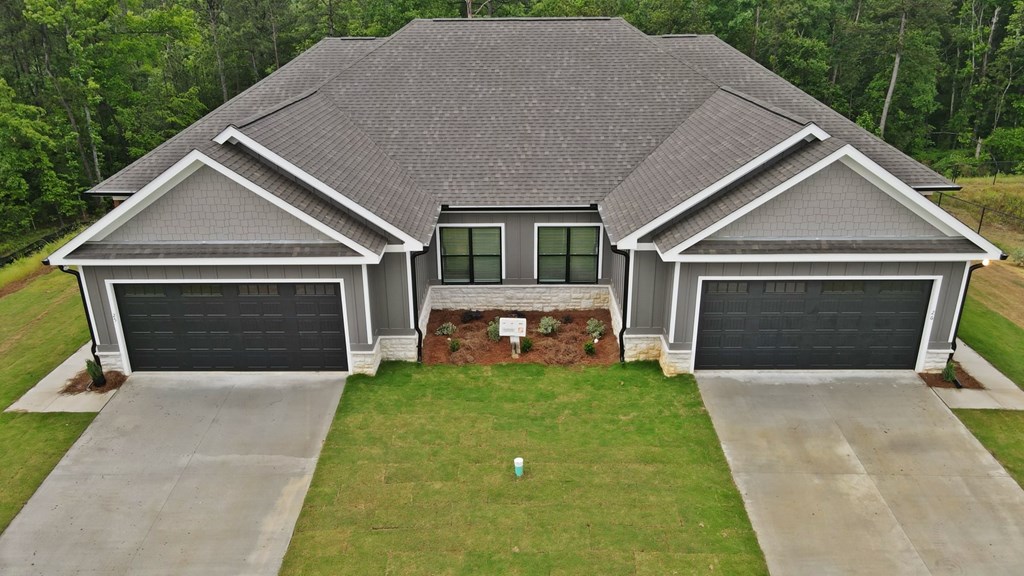 A house with a grey roof and two garages.