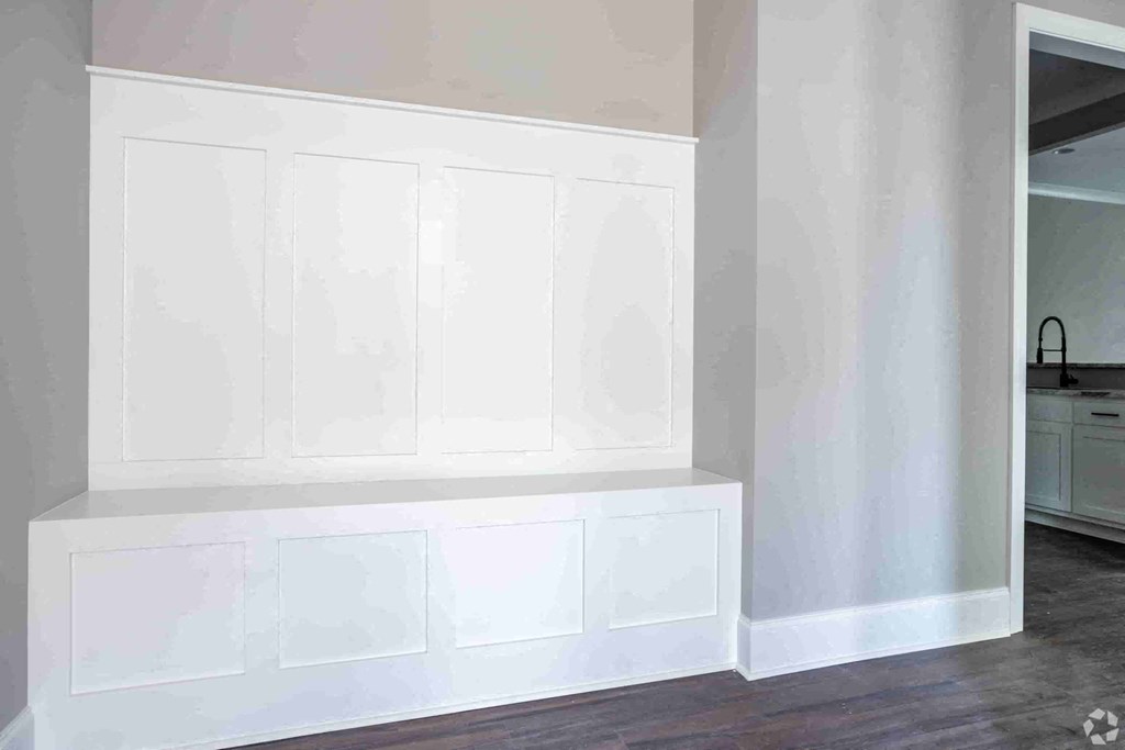 A white kitchen with a white countertop and white cabinets.