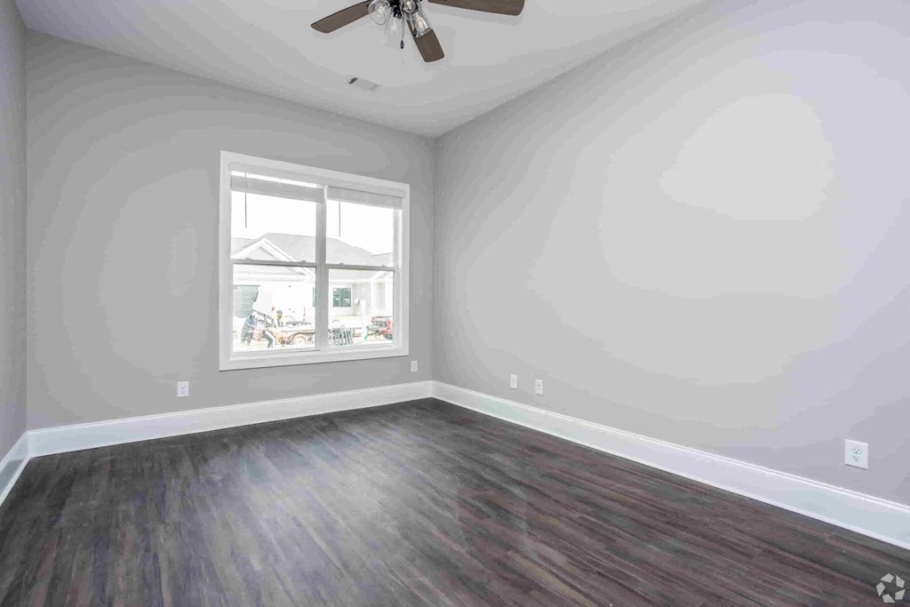 A room with a window and a ceiling fan.