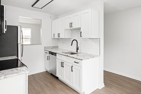 a kitchen with white cabinets and a sink and a refrigerator