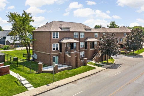 the view of a brick apartment building from the street