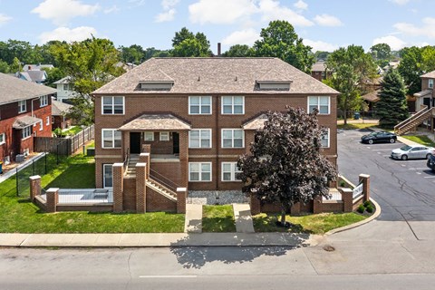 an aerial view of a large brick house on a city street