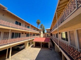 a courtyard between two apartment buildings with a red roof
