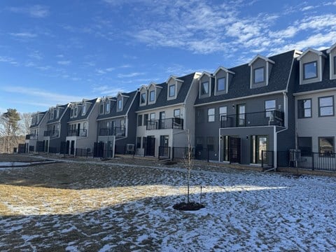 an empty yard in front of an apartment building in the snow