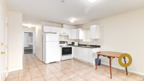 a kitchen with white cabinets and appliances and a wooden table