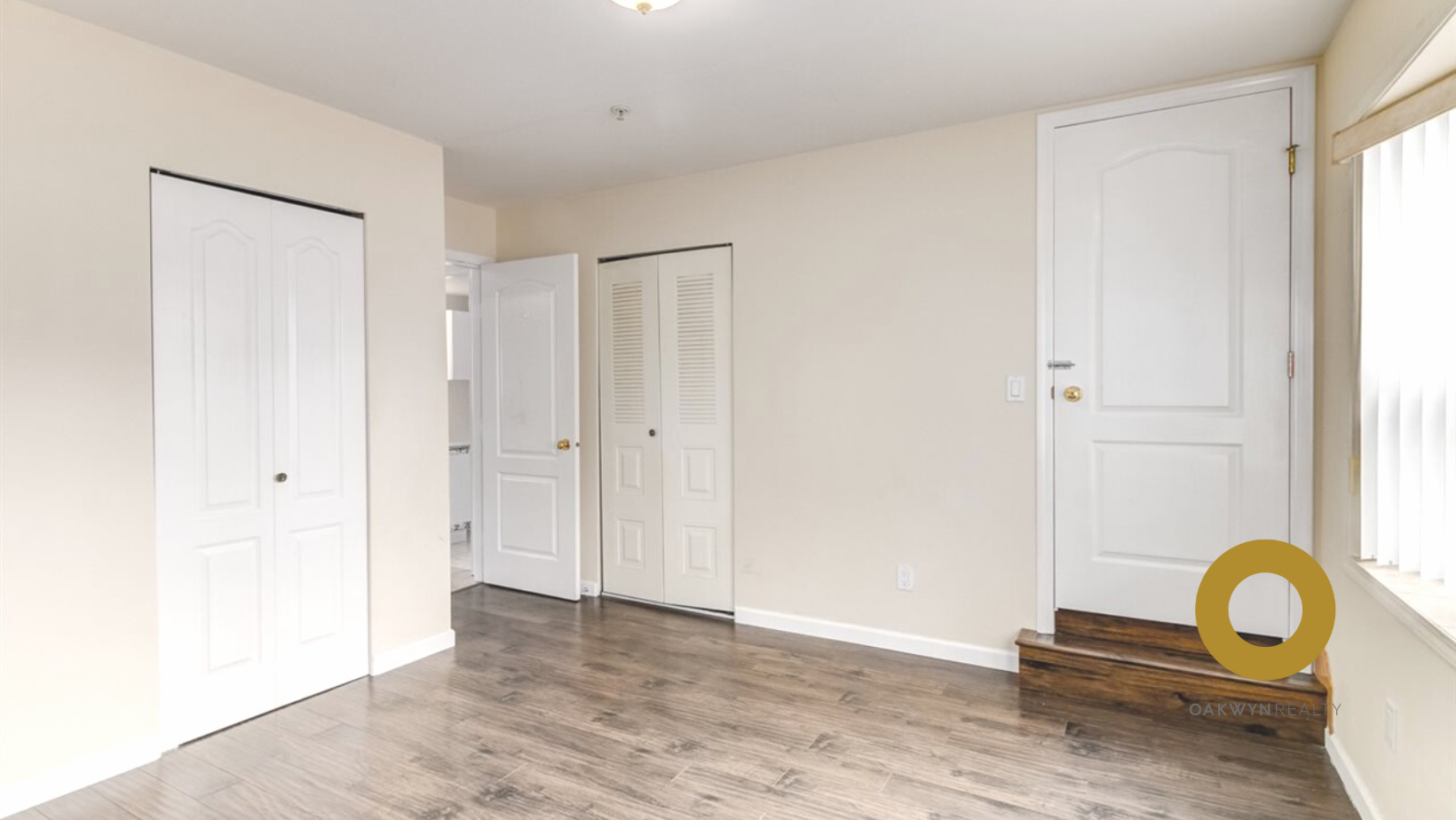 a living room with white doors and a hard wood floor