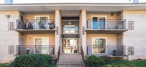 Apartment building with a balcony on the second floor.