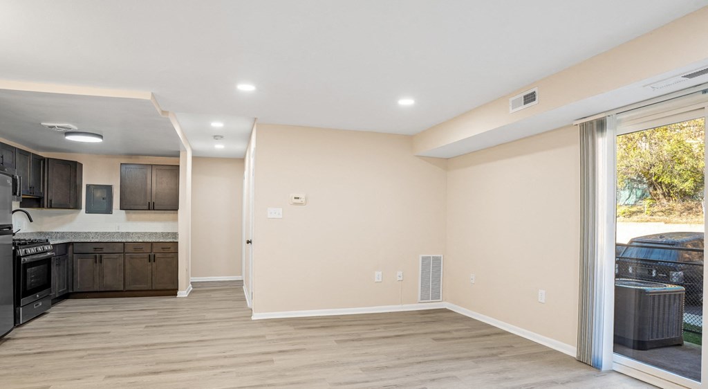 A spacious kitchen and living room with a sliding glass door.