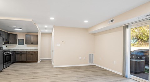 A spacious kitchen and living room with a sliding glass door.