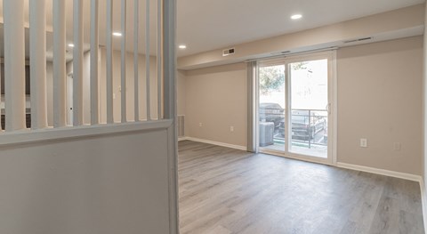 A room with a sliding glass door leading to a balcony.