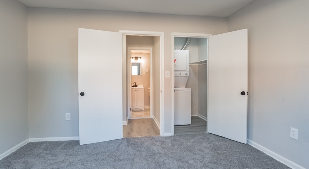 A room with a carpeted floor and a doorway leading to another room.